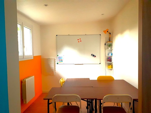 salle de soutien lumineuse avec mur jaune et mobilier pliable pour un amenagement flexible